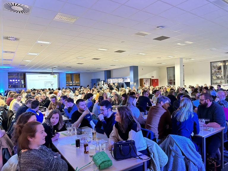 Een zaal vol mensen die aan het deelnemen zijn.